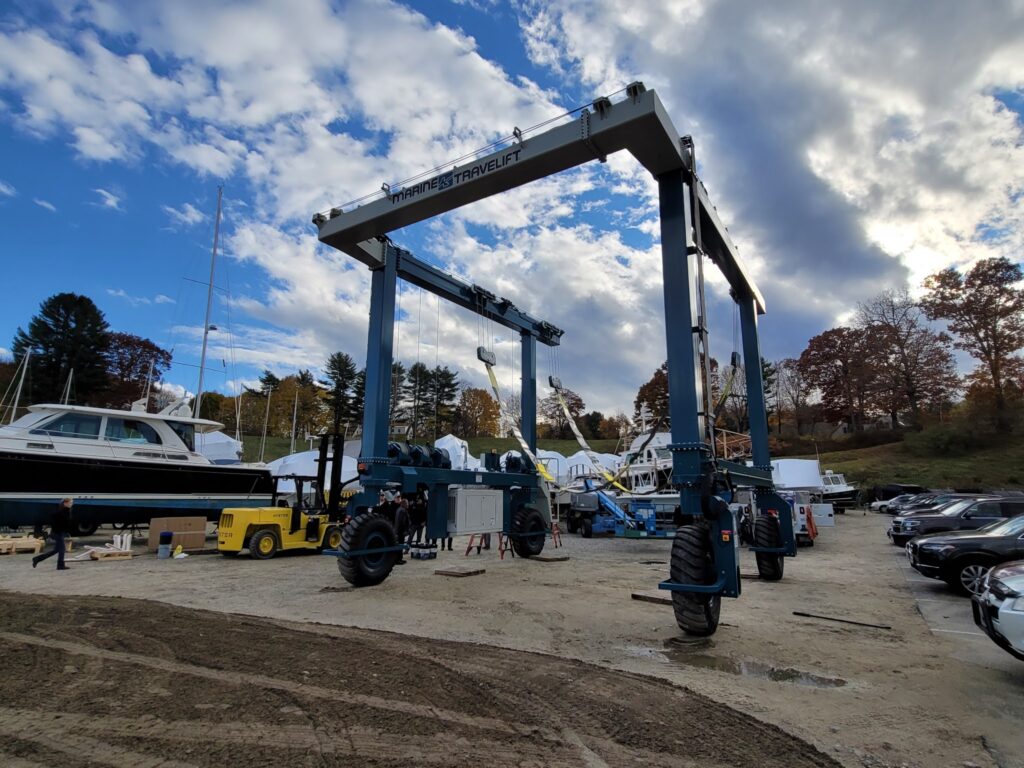 Großer mobiler Kran auf einer Bootswerft, bereit, Yachten unter herbstlichem Himmel zu bewegen.